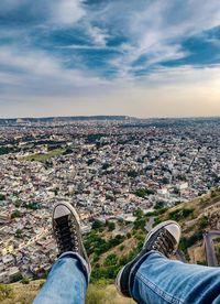 Low section of man with cityscape against sky