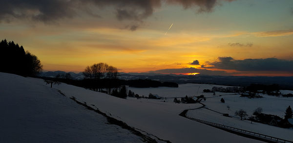 Scenic view of snow covered trees against sky during sunset