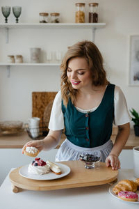 Girl shifts cakes on a dish in the kitchen