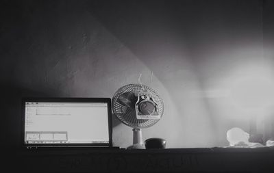 Laptop and fan on table at home