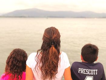 The mother, the daughter and the son looking the sea