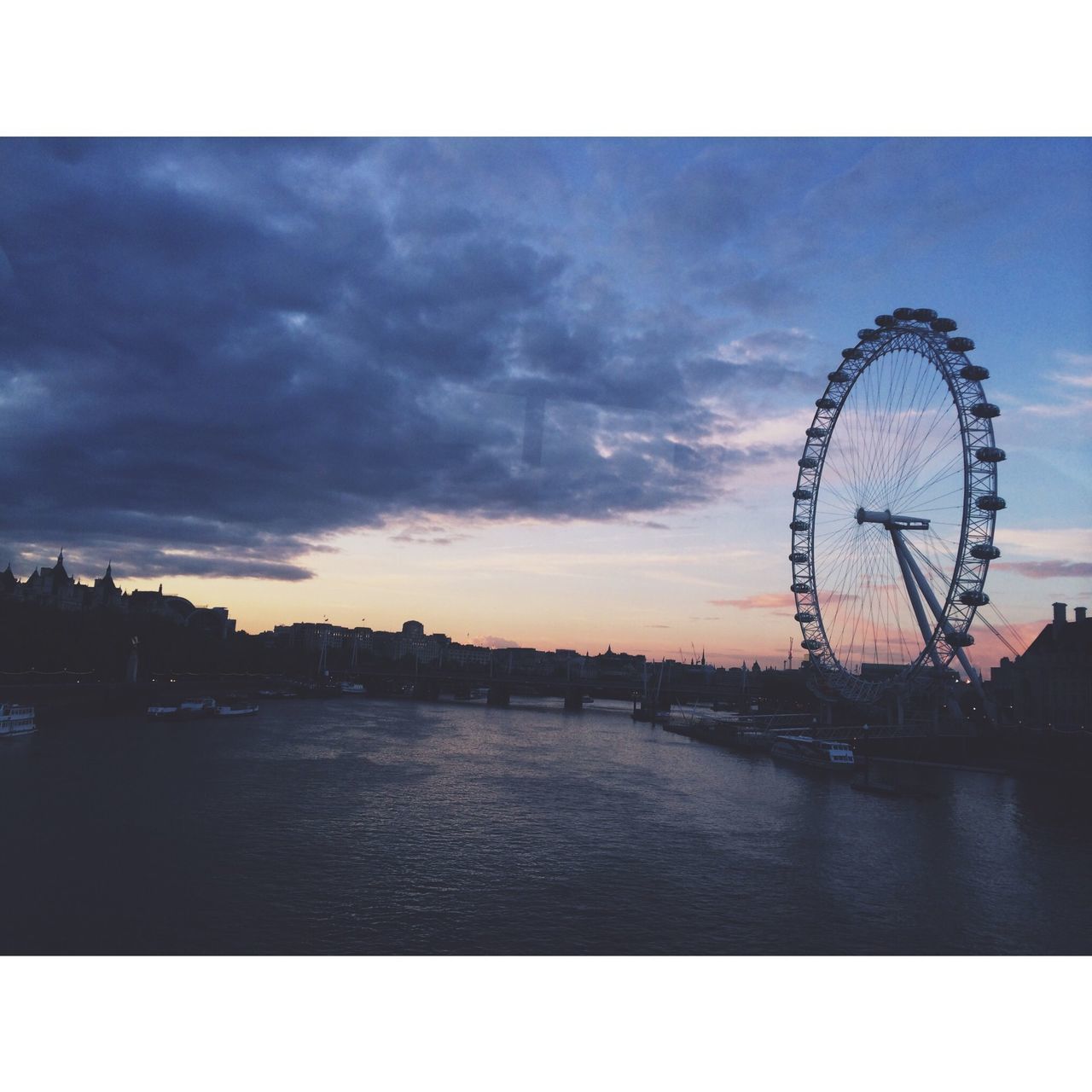 ferris wheel, sky, built structure, architecture, cloud - sky, building exterior, amusement park ride, amusement park, waterfront, water, city, arts culture and entertainment, sunset, auto post production filter, river, cloud, transfer print, outdoors, tower, cloudy