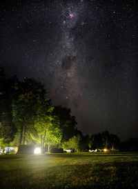 Scenic view of illuminated field against sky at night