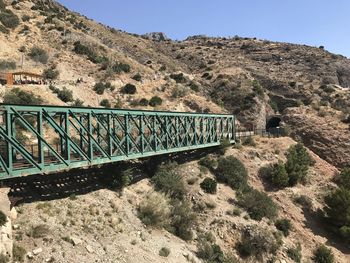 Bridge over mountain against clear sky