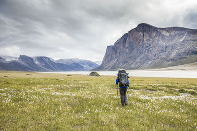 Rear view of man on field against mountains