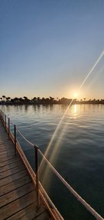 Scenic view of lake against clear sky during sunset