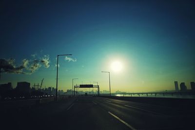 Road in city against clear sky during sunset