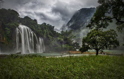 Scenic view of waterfall against sky