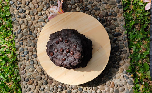 High angle view of chocolate cookies on wood board against stone background