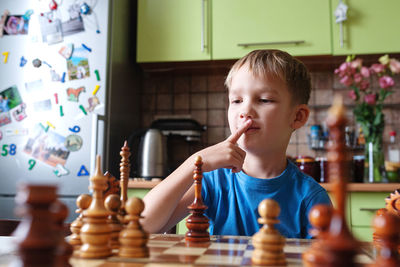 Close-up of boy playing chess at home