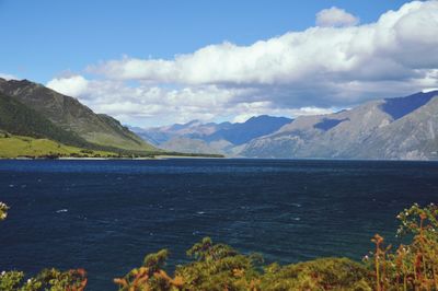Scenic view of sea and mountains against sky
