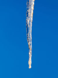 Close-up of icicles against clear blue sky
