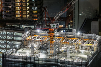 Illuminated factory at construction site at night