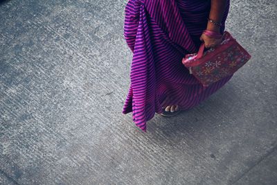 Low section of woman walking on street