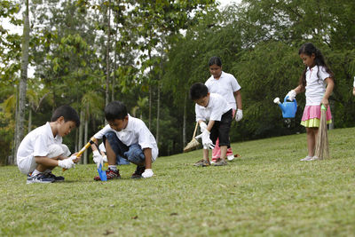 Group of people playing on plants against trees