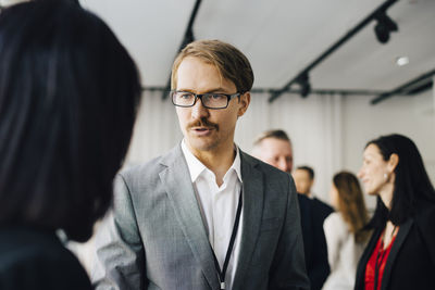 Male coworker talking to female colleague in office