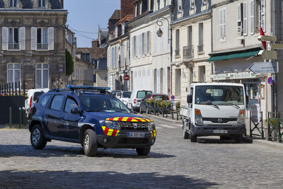 Cars on road by buildings in city