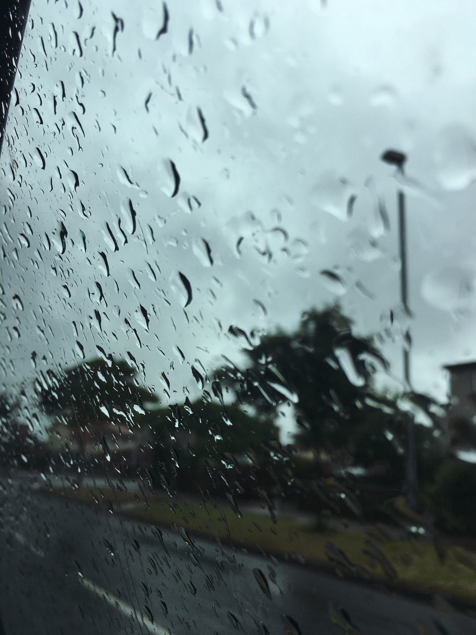 CLOSE-UP OF WET GLASS WINDOW IN RAINY SEASON