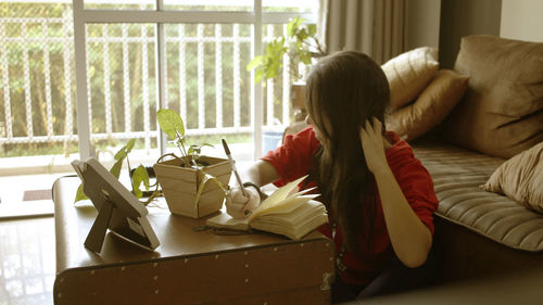 Woman sitting by window at home