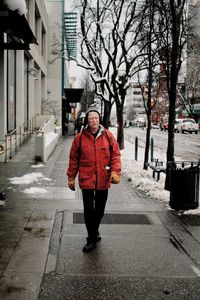 Portrait of man standing on footpath in winter