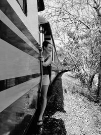 Smiling woman standing on train doorway