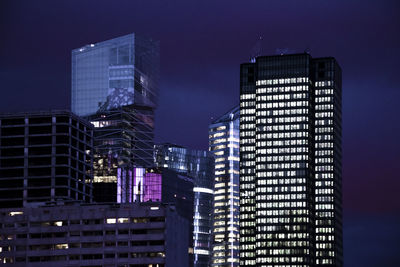 Low angle view of illuminated buildings against sky at night