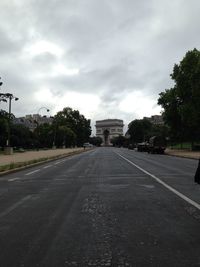 Empty road against cloudy sky