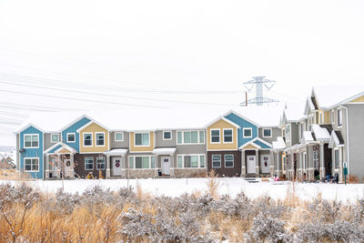 Houses and buildings against sky during winter