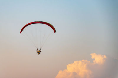 Low angle view of person paragliding against sky