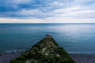 Scenic view of sea against cloudy sky