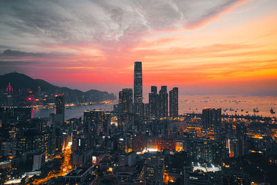 Illuminated buildings against sky during sunset
