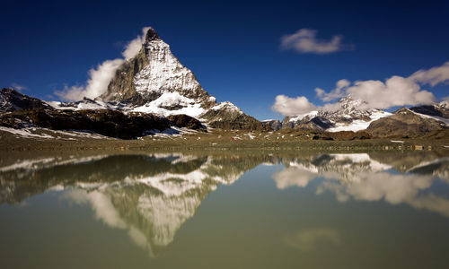 Scenic view of lake and snowcapped mountains against sky