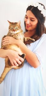 Beautiful woman carrying cat at home