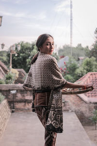 Young woman looking at city against sky