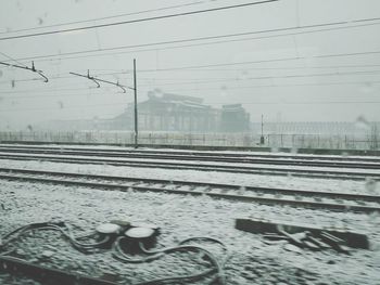 Wet railroad tracks against sky during rainy season