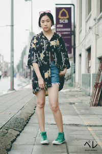 Portrait of woman standing on footpath