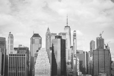 Buildings in city against cloudy sky