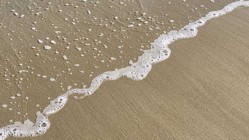 High angle view of waves and foam on chatham, cape cod sandy beach