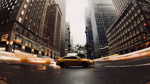 Cars on city street amidst buildings