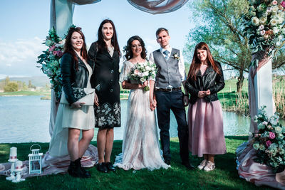 Women standing by people against wall