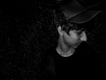 Portrait of boy wearing sunglasses against black background