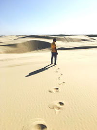 Full length rear view of man standing on desert