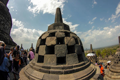 Group of people in temple against sky