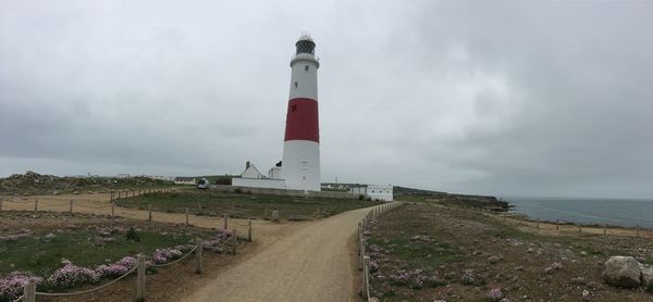 Lighthouse by sea against sky