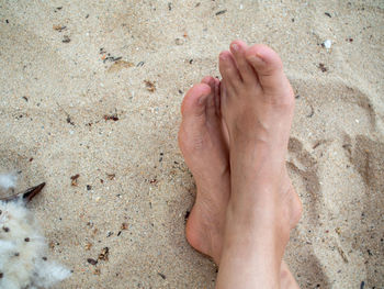 Low section of feet on sand