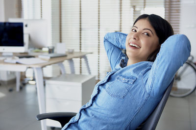 Portrait of smiling young woman sitting on table