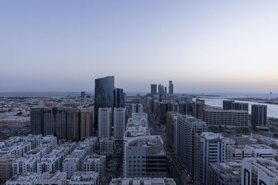 Aerial view of buildings in city against clear sky