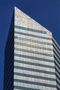 Low angle view of modern building against clear blue sky