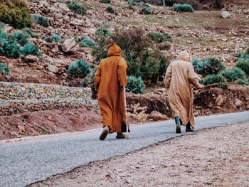 Rear view of a couple walking on road
