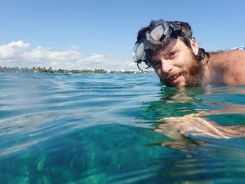 Portrait of man swimming in sea against sky